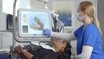 assistant pointing to dental scan