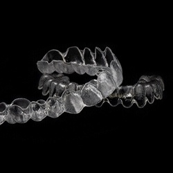 Two generic clear aligners arranged against dark background