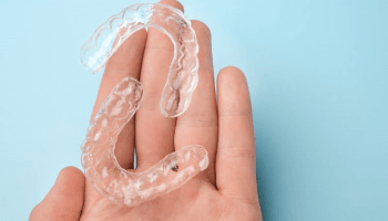 Two clear aligners resting on person’s hand