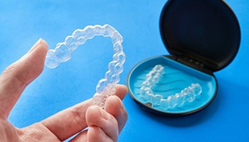 Hand placing Invisalign aligner into storage container