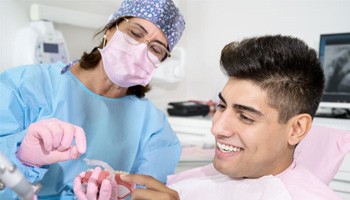 Dental patient looking at Invisalign aligner