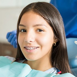 Smiling girl with braces in dental treatment chair
