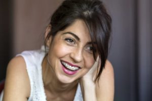 A woman with braces smiling.