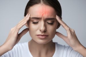 Frowning woman with headache related to her TMJ