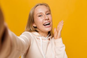 Teen girl taking selfie after learning fun facts about braces