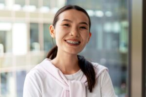 Smiling woman in office building, wearing braces 